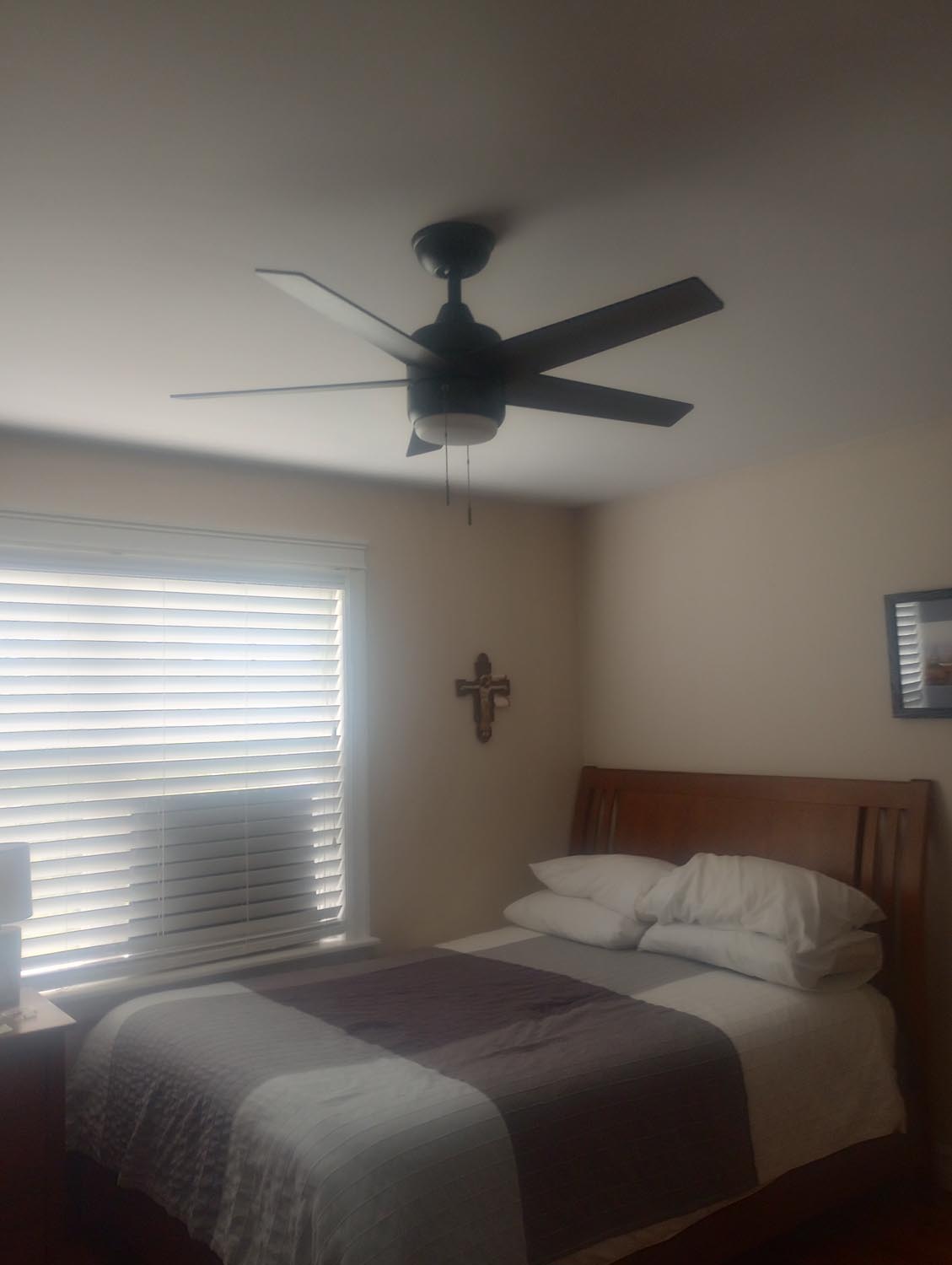 Finished ceiling fan installation in a modern bedroom by Absolute Power Electrical.