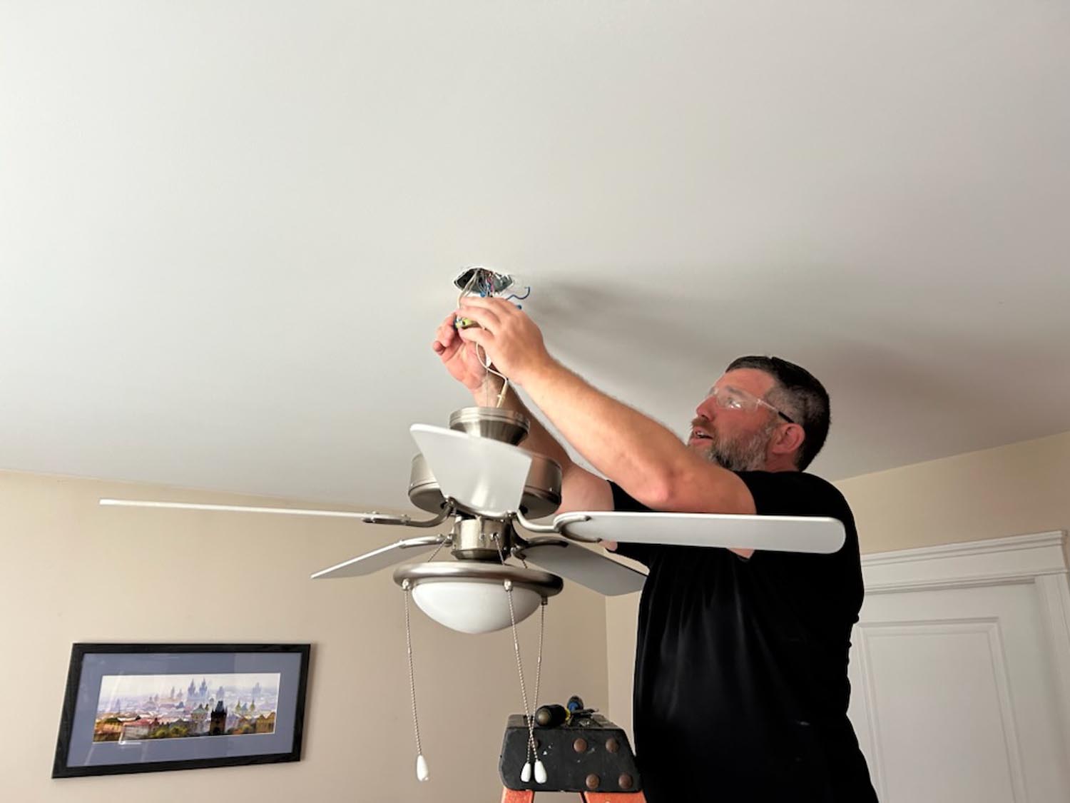 Image of Colin Cairns, founder of Absolute Power Electrical, working on a residential electrical ceiling fan installation.